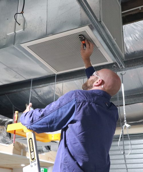 Man working on air vent.