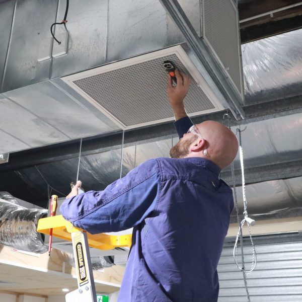 Man working on air vent.